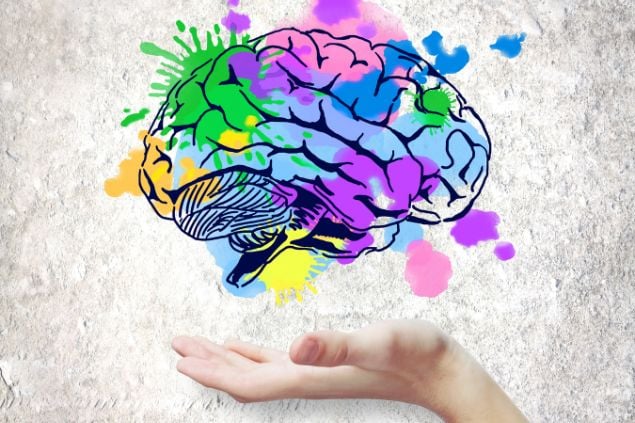 Imagem de uma mão apontando para um cérebro colorido, como se estivesse pintado