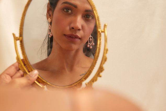 Imagem do reflexo de uma mulher que está se olhando no espelho