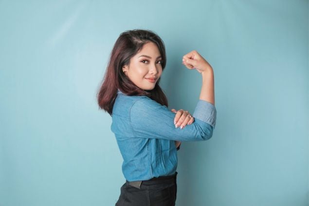 Mulher mostrando sua força no braço.