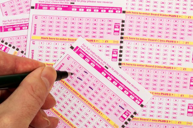 Várias cartelas de lotérica sendo marcadas uma caneta
