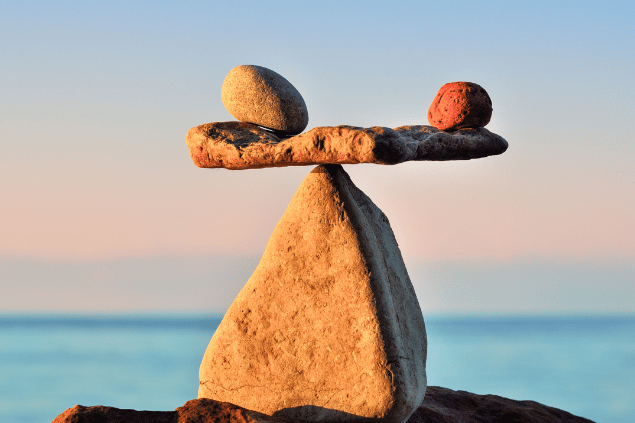 Duas pedras equilibradas em cima de uma outra pedra