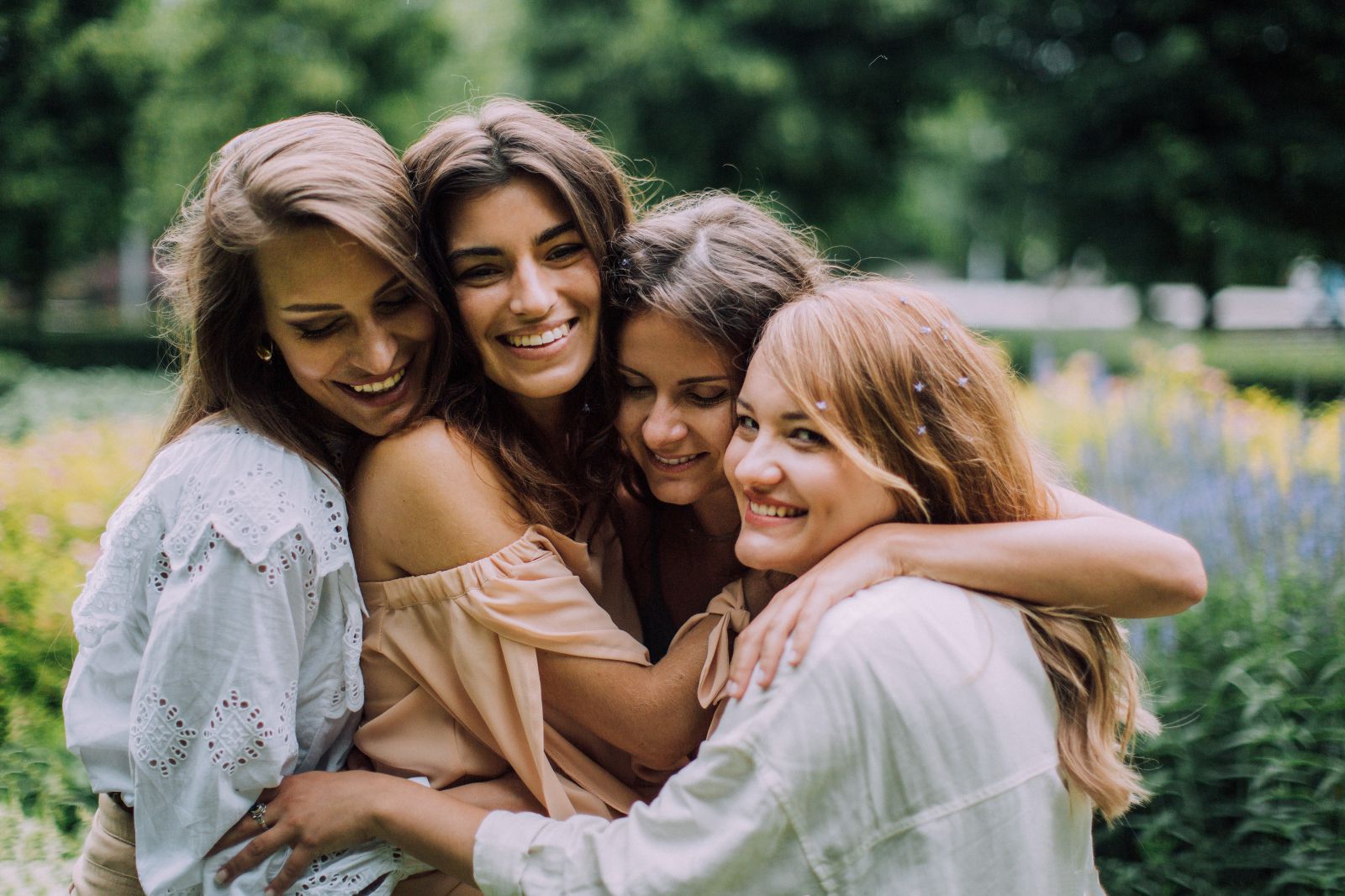Quatro mulheres se abraçando e sorrindo