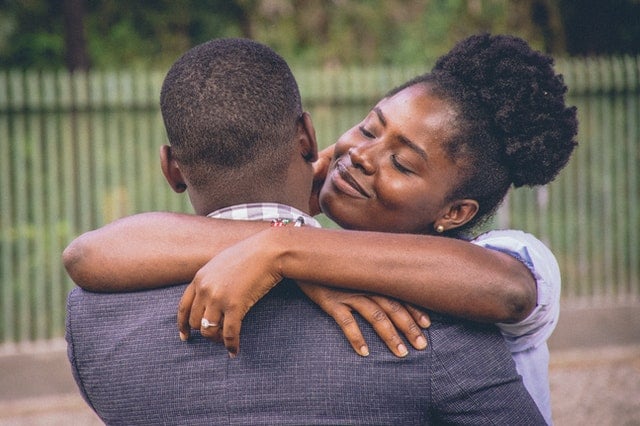 Casal de homem e mulher negros se abraçando