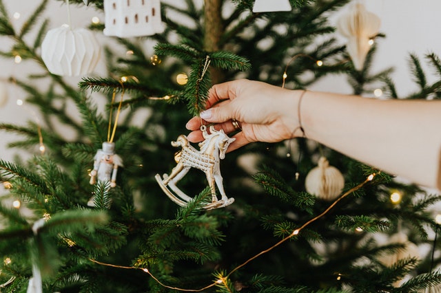 Um enfeite sendo colocado em uma árvore de Natal