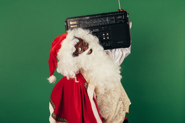 Papai Noel segurando um rádio no ombro esquerdo