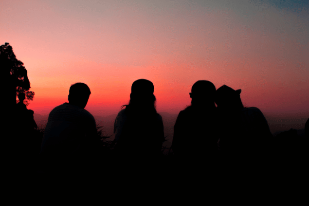 Silhueta de quatro amigos durante um pôr-do-sol