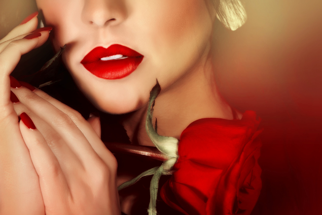 Mulher sensualizando com lábios vermelhos e segurando uma rosa